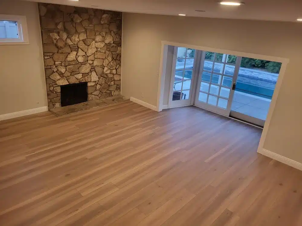 SPC flooring repair in living room near stone fireplace