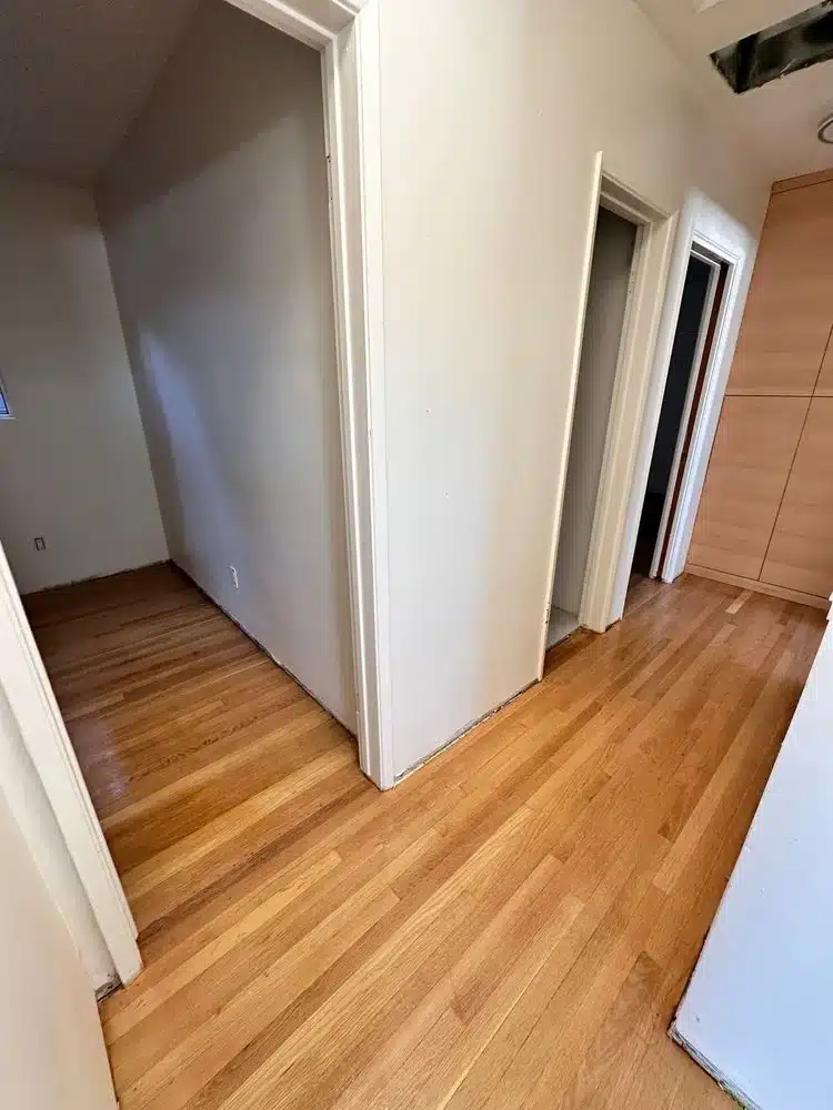 Freshly installed hardwood floors in a hallway with clean, smooth finish"